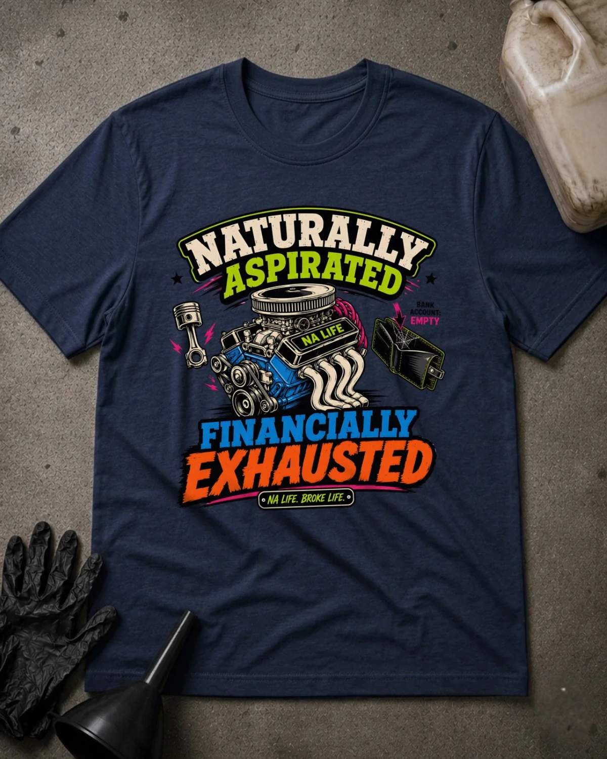 Front of navy T-shirt with an engine, piston and empty wallet graphic reading “Naturally Aspirated, Financially Exhausted.”