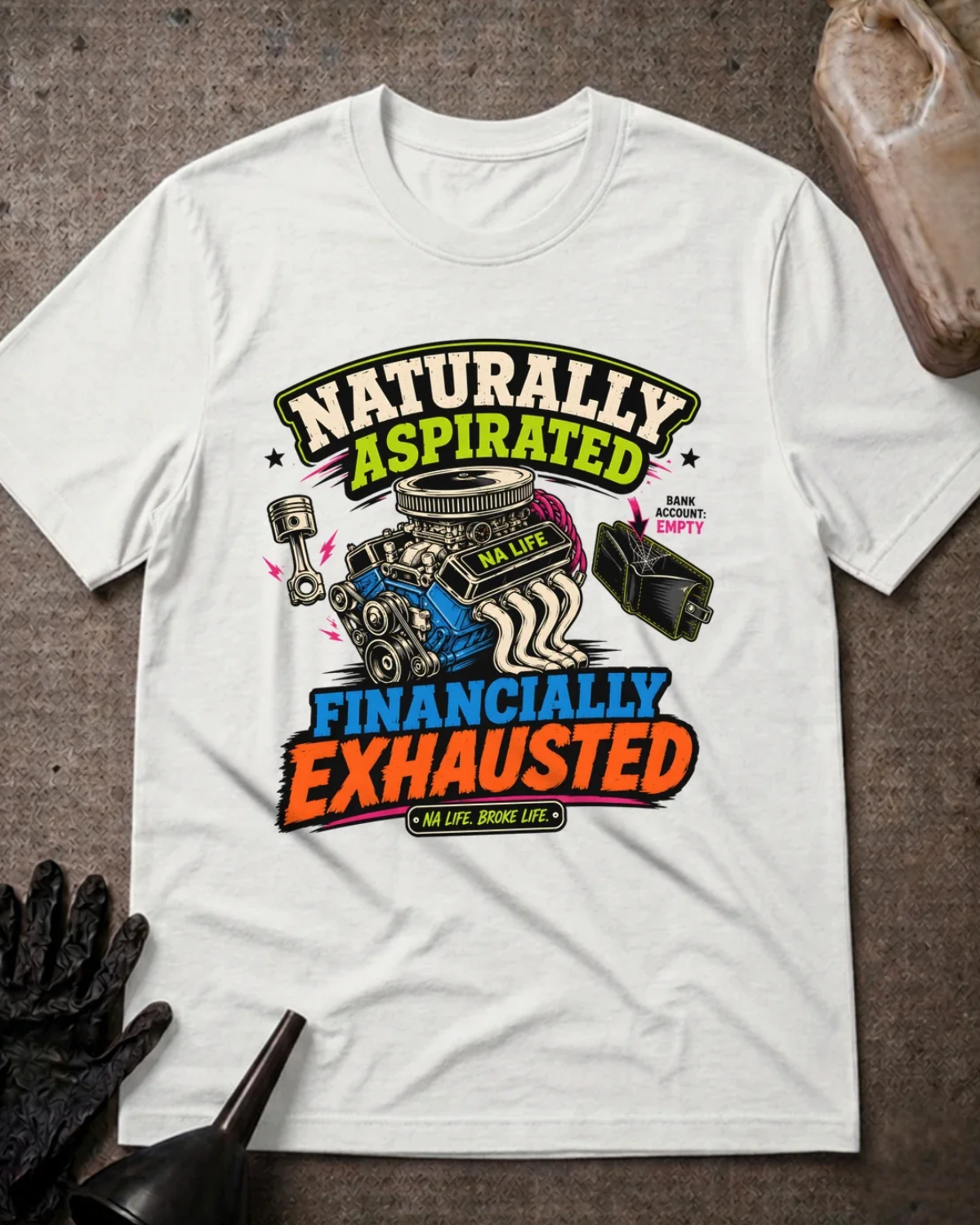 Front of white T-shirt with an engine, piston and empty wallet graphic reading “Naturally Aspirated, Financially Exhausted.”