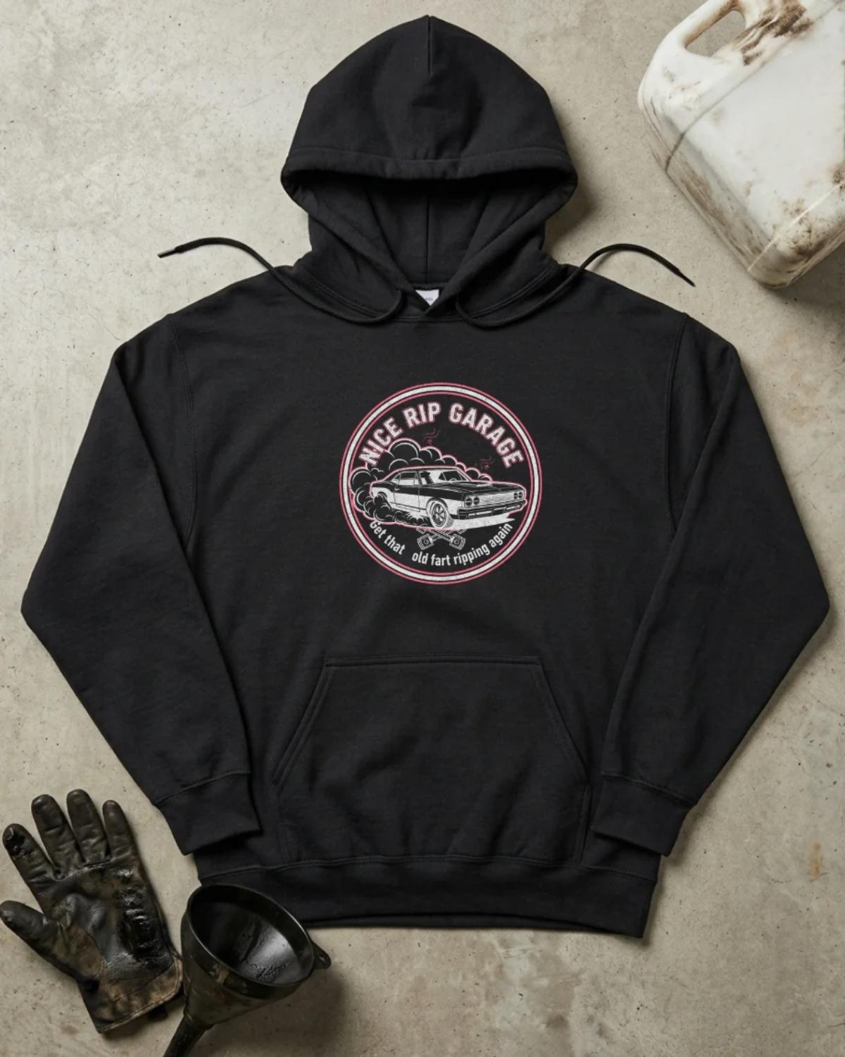 Front of black hoodie with a circular Nice Rip Garage logo featuring a classic muscle car amid tire smoke and “Get That Old Fart Ripping Again” text.