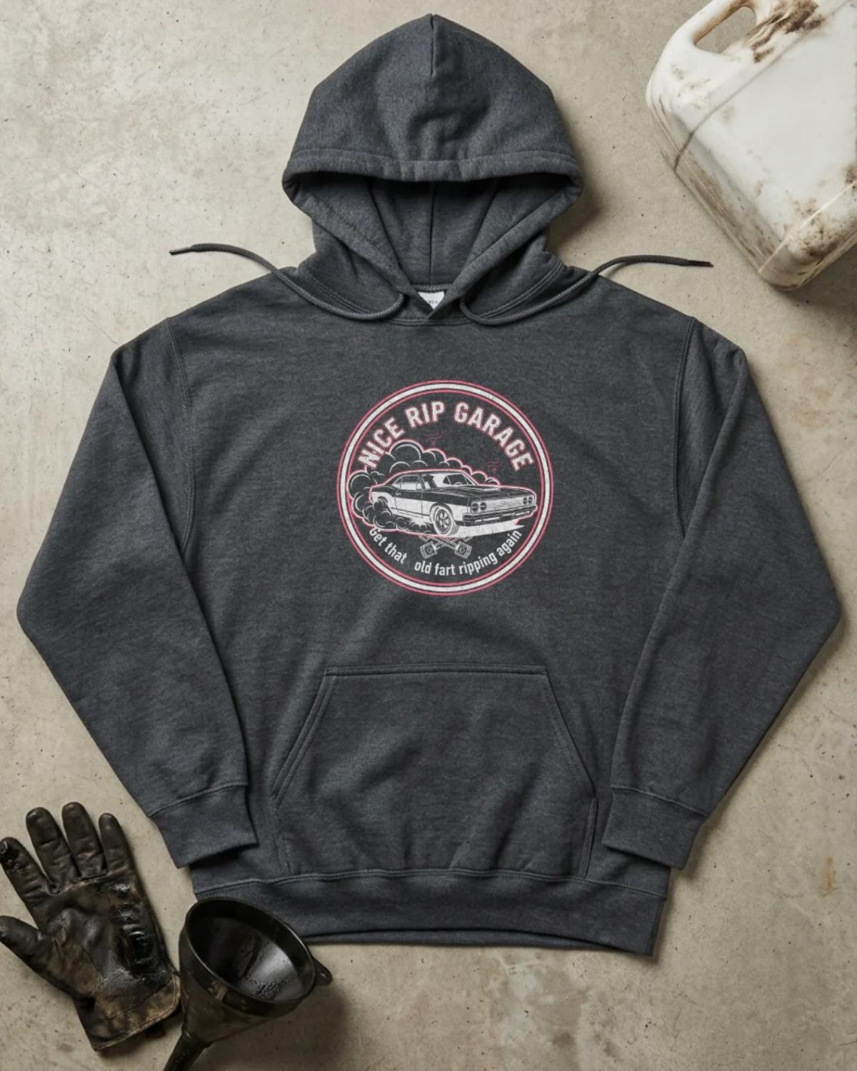 Front of dark heather hoodie with a circular Nice Rip Garage logo featuring a classic muscle car amid tire smoke and “Get That Old Fart Ripping Again” text.