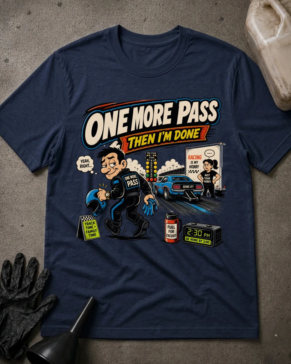 Front of navy T-shirt with a cartoon racer holding a helmet, blue drag car and woman beside a trailer, reading “One More Pass, Then I’m Done.”