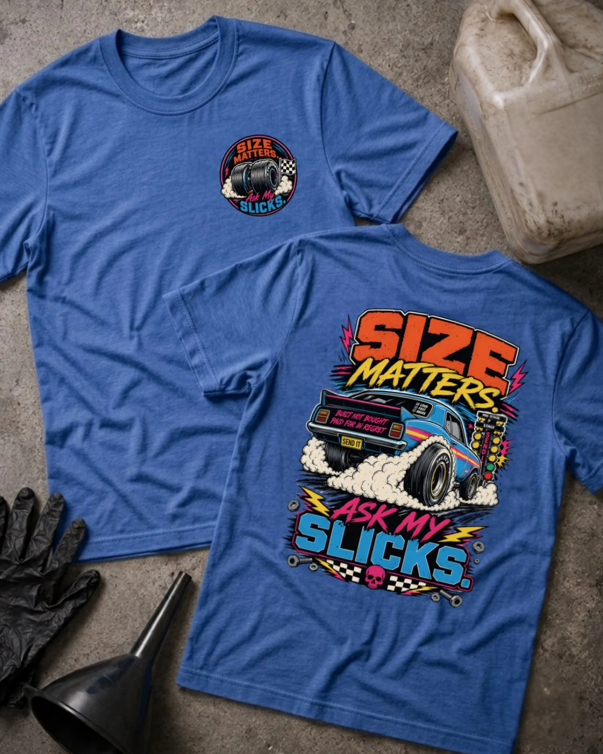 Front and back of heather true royal blue “Size Matters, Ask My Slicks” T-shirt with a small tire chest emblem and blue drag car with oversized rear slicks and tire smoke on the back.