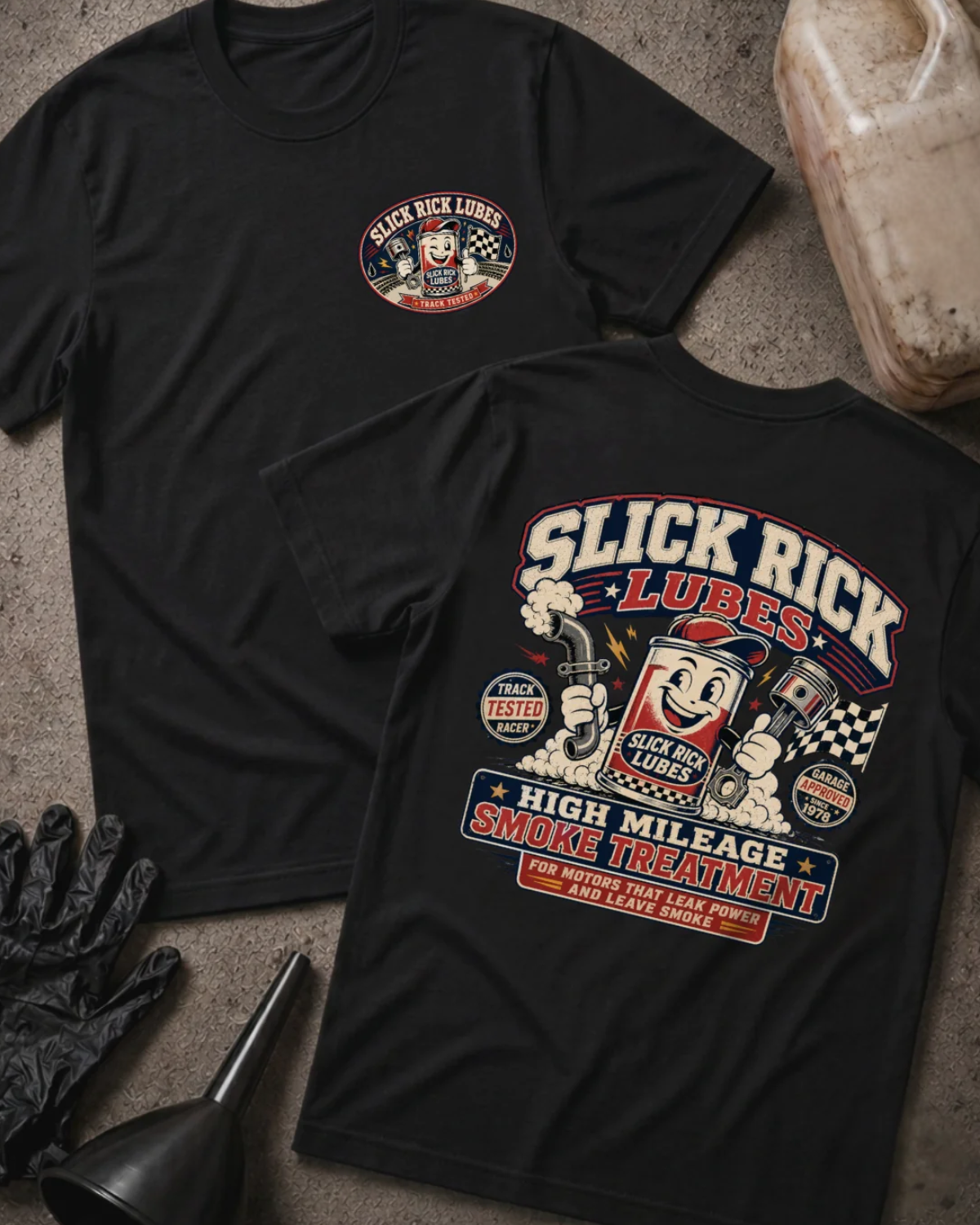 Front and back of black Slick Rick Lubes T-shirt with a chest logo and cartoon motor oil can holding a piston and exhaust pipe above “High Mileage Smoke Treatment.”