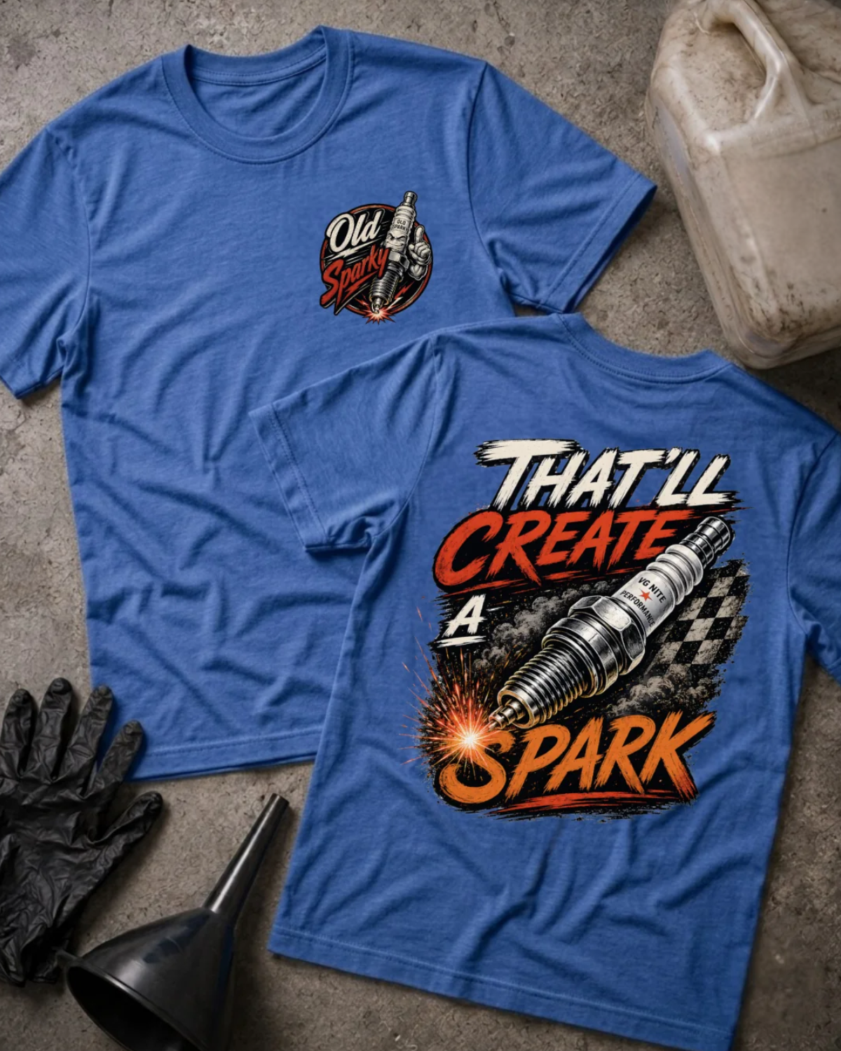 Front and back of heather true royal blue T-shirt with an “Old Sparky” chest emblem and large sparking automotive spark plug over a checkered flag, reading “That’ll Create a Spark.”