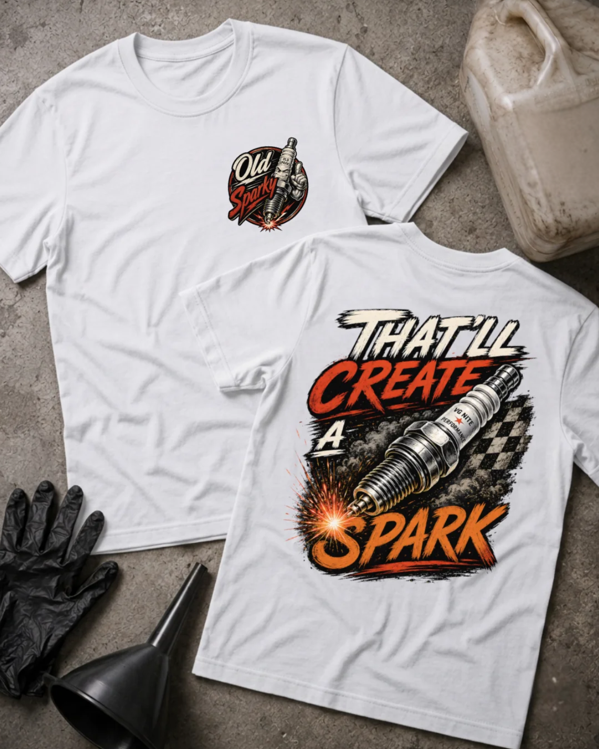 Front and back of white T-shirt with an “Old Sparky” chest emblem and large sparking automotive spark plug over a checkered flag, reading “That’ll Create a Spark.”