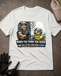 Front of white T-shirt with a smiling racer giving a thumbs-up beside a nervous helmeted duck, reading “When You Think You Suck and Pull in the Lanes with a Duck.”