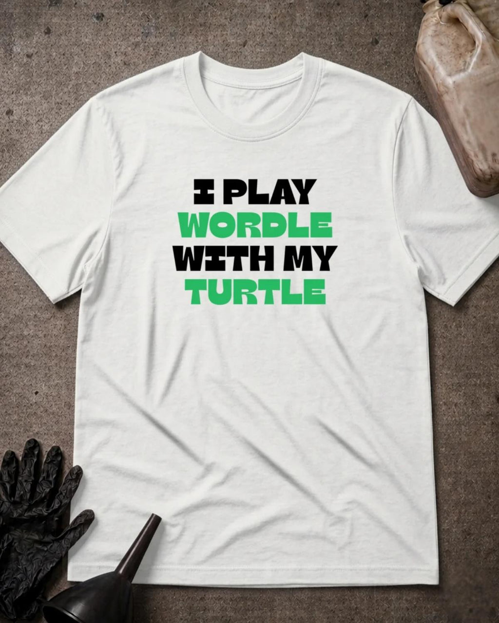 White Wordle Turtle T-shirt featuring bold black and green lettering reading “I play Wordle with my turtle.”