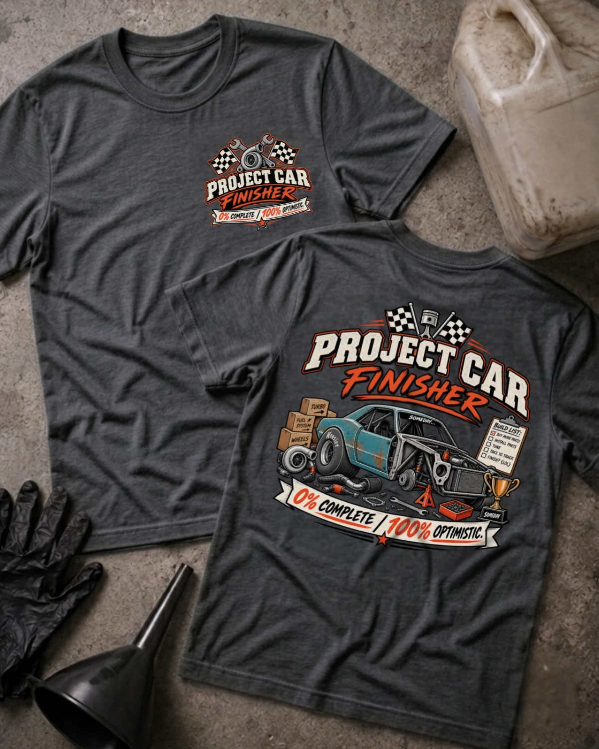 Front and back of Project Car Finisher dark grey heather T-shirt with chest logo, unfinished teal car surrounded by parts and tools, and “0% complete / 100% optimistic” slogan.