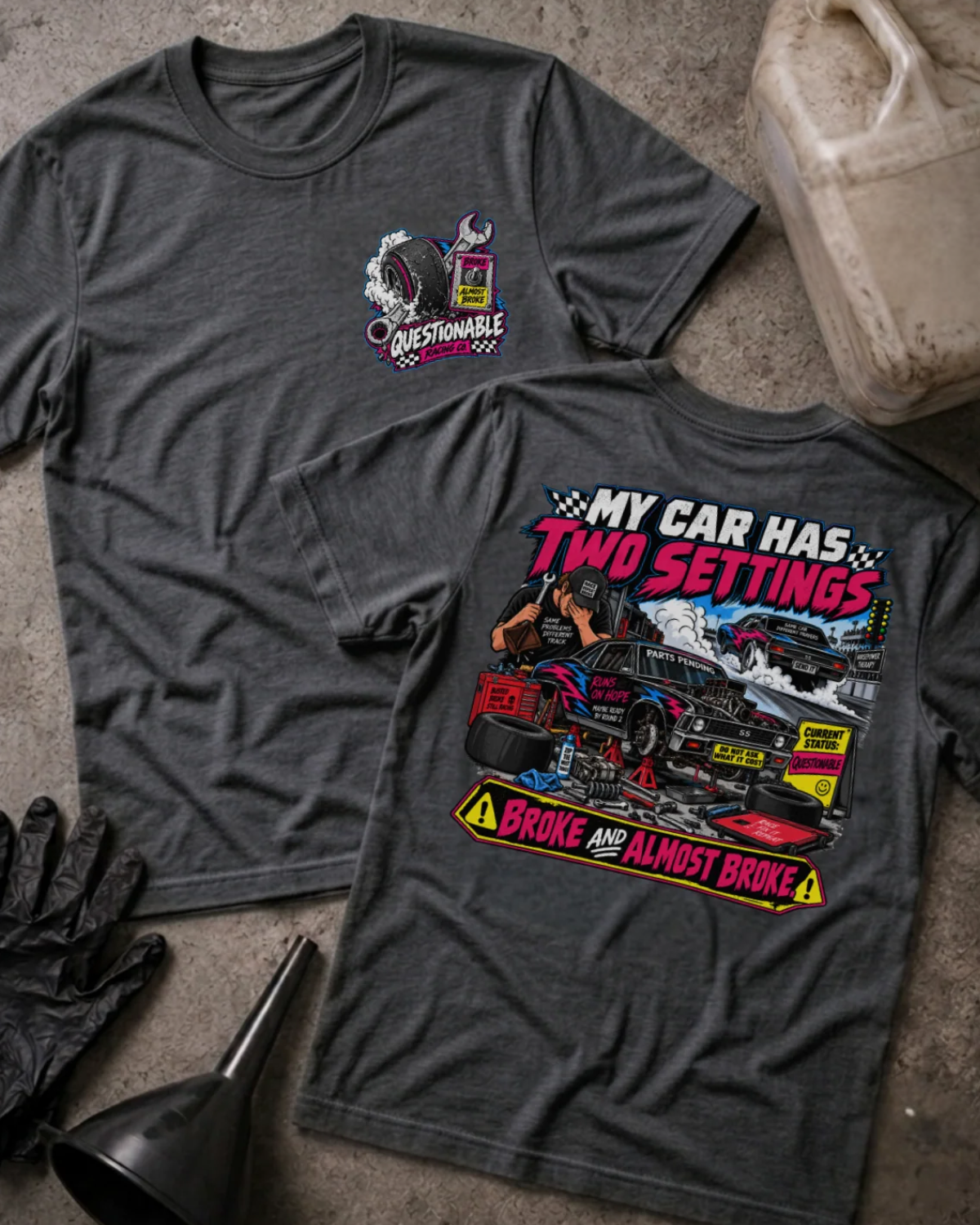 Front and back of Questionable Racing Co. dark grey heather T-shirt with chest logo, mechanic beside a car on jack stands, and “My car has two settings: broke and almost broke” slogan.