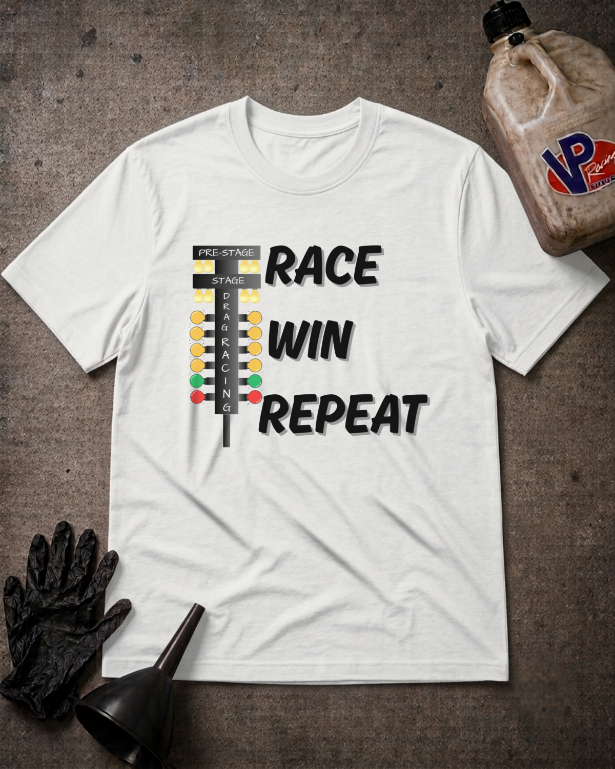 A white graphic t-shirt laid flat on a dark textured surface, featuring a race flag graphic and the words 'RACE WIN REPEAT' in black. The shirt is styled with a black work glove, a black funnel, and a bottle of VP Racing Oil in the corners.