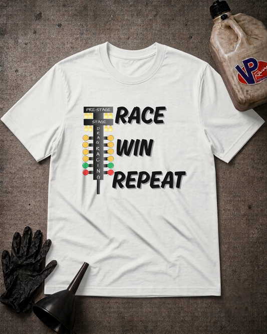 A white graphic t-shirt laid flat on a dark textured surface, featuring a race flag graphic and the words 'RACE WIN REPEAT' in black. The shirt is styled with a black work glove, a black funnel, and a bottle of VP Racing Oil in the corners.