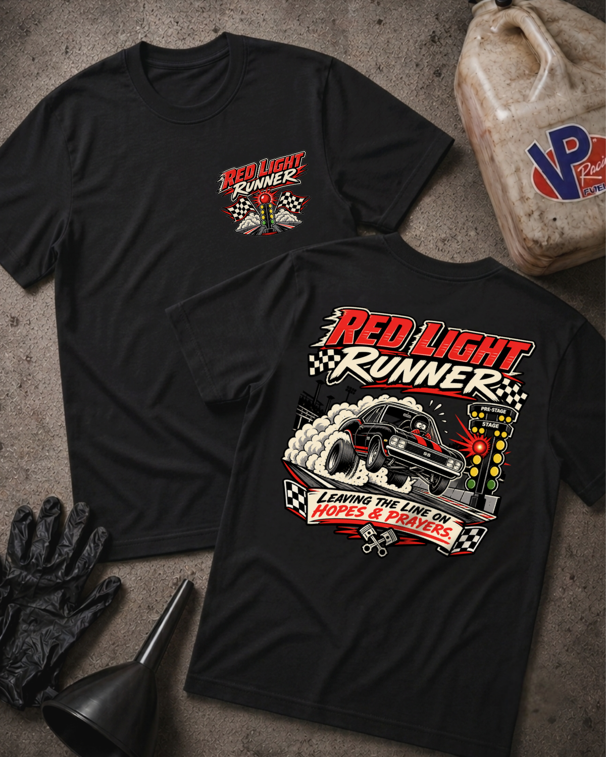Two black graphic T-shirts laid flat on a concrete surface, showing the front and back designs. The shirts feature a racing-themed graphic with the text 'Red Light Runners' and a race car illustration.