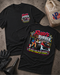 Two black graphic T-shirts laid flat on a concrete floor, showing the front and back designs for 'Ruby's Rubber Service'. The front features a small chest logo, while the back displays a large graphic with a woman, tires, and a race car.