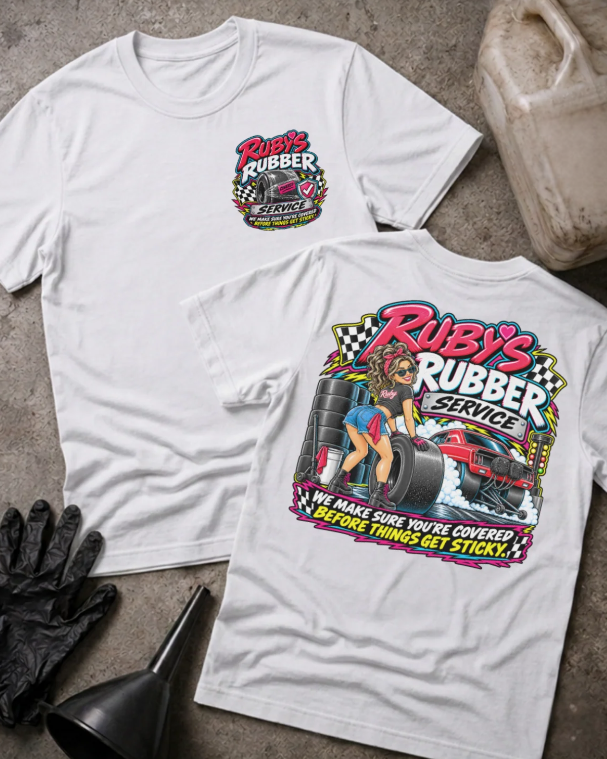 Front and back of Ruby’s Rubber Service white T-shirt with chest logo, woman beside racing tires and a red drag car, and “We make sure you’re covered before things get sticky” slogan.