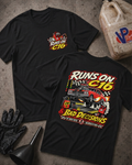 Two black graphic T-shirts laid flat on a textured gray surface, with automotive-themed printed artwork and the text 'RUNS ON C16 & BAD DECISIONS.' One shirt shows a small chest logo, and the other shows a large back graphic with a race car illustration and the phrase 'PIT CREW TESTED, TRACK OFFICIAL DISAPPROVED'.