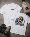 Two white graphic T-shirts laid flat on a gray concrete surface, with a black funnel, black gloves, and a VP Racing fuel jug nearby. The front shirt has a small dark chest logo graphic, and the back shirt has a large colorful cartoon racer graphic with the text 'THE PUN-ISHER' and 'shirtsandgigglesbazaar.com'
