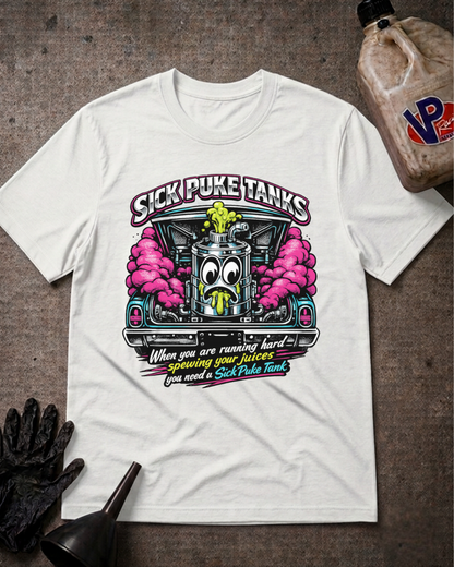 A white graphic t-shirt laid flat on a textured gray surface, featuring a cartoon fuel pump with pink clouds and the text 'SICK PUKE TANKS' and 'When you are running hard you need a Sick Puke Tank'. A plastic jug, black gloves, and a funnel are styled around the shirt.