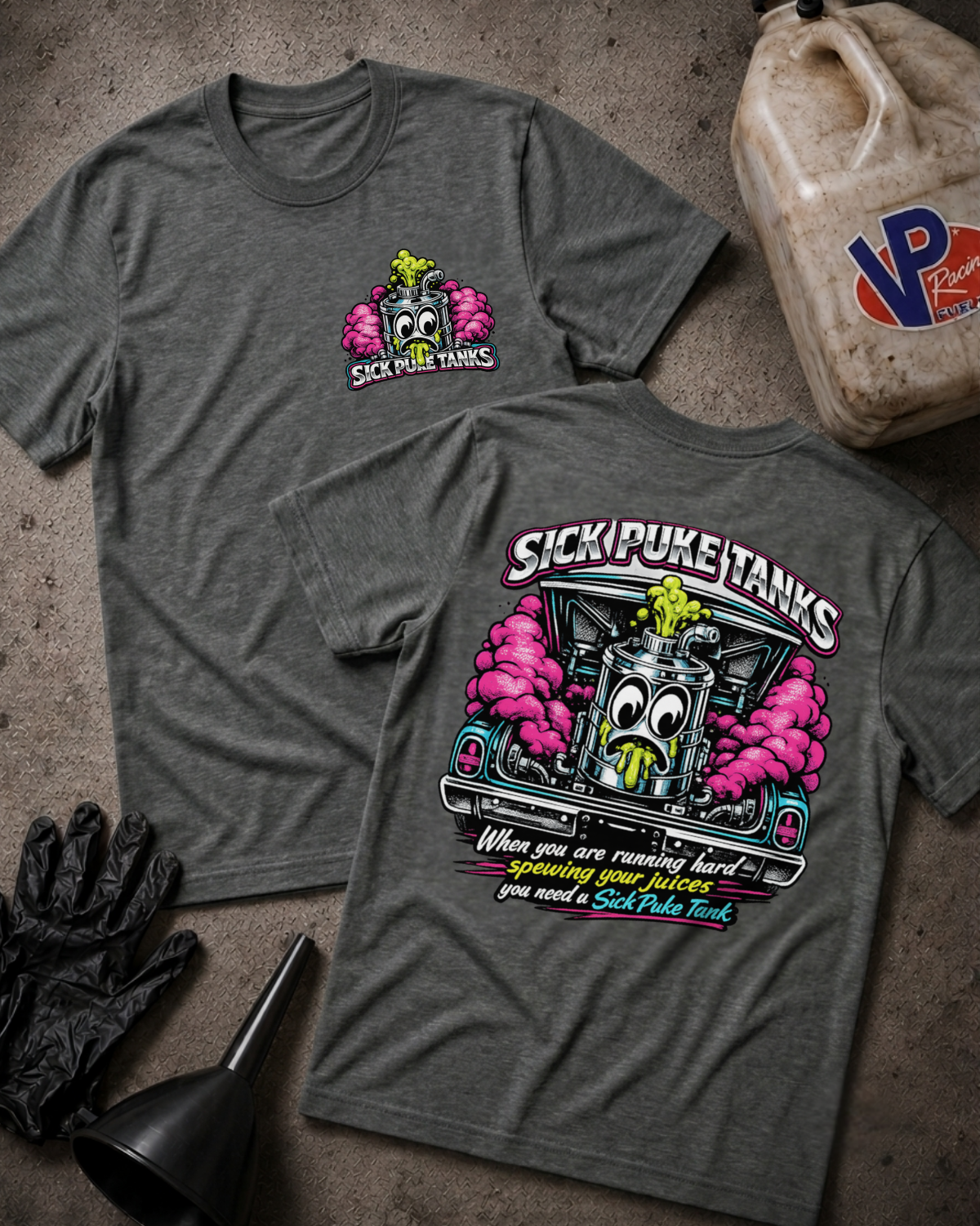 Two heather dark gray t-shirts displayed flat on a textured concrete surface, showing both the front and back designs. The front features a small pink and green cartoon tank graphic with the text 'SICK PUKE TANKS'.