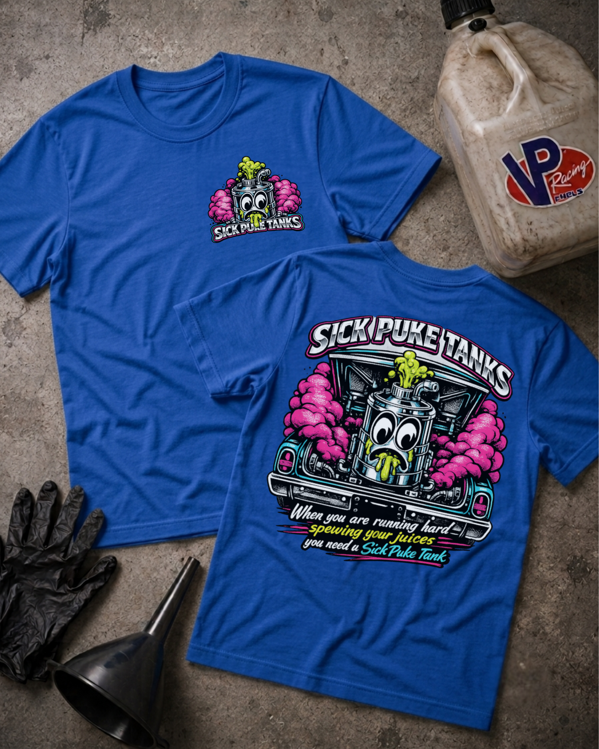 Two blue graphic T-shirts laid flat on a textured gray surface, with a black oil jug, black gloves, and a funnel nearby. The front shirt shows a small chest graphic of a cartoon gas pump with pink smoke and the text 'SICK PUKE TANKS.