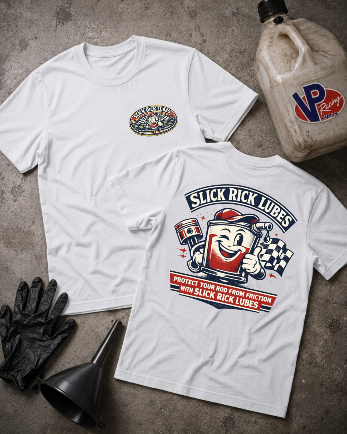 Two white T-shirts laid flat on a gray concrete surface, showing the front and back graphics for Slick Rick Lubricants. The front has a small oval chest logo, and the back has a large colorful racing graphic with a mascot and text.