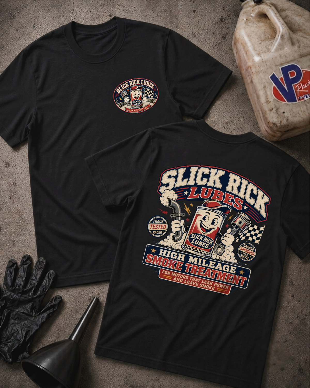 Two black graphic T-shirts laid flat on a textured gray surface, showing the front and back designs for Slick Rick Lubes. The front has a small circular chest logo, and the back features a large vintage-style illustration with the text 'Slick Rick Lubes' and 'High Mileage Smoke Treatment.