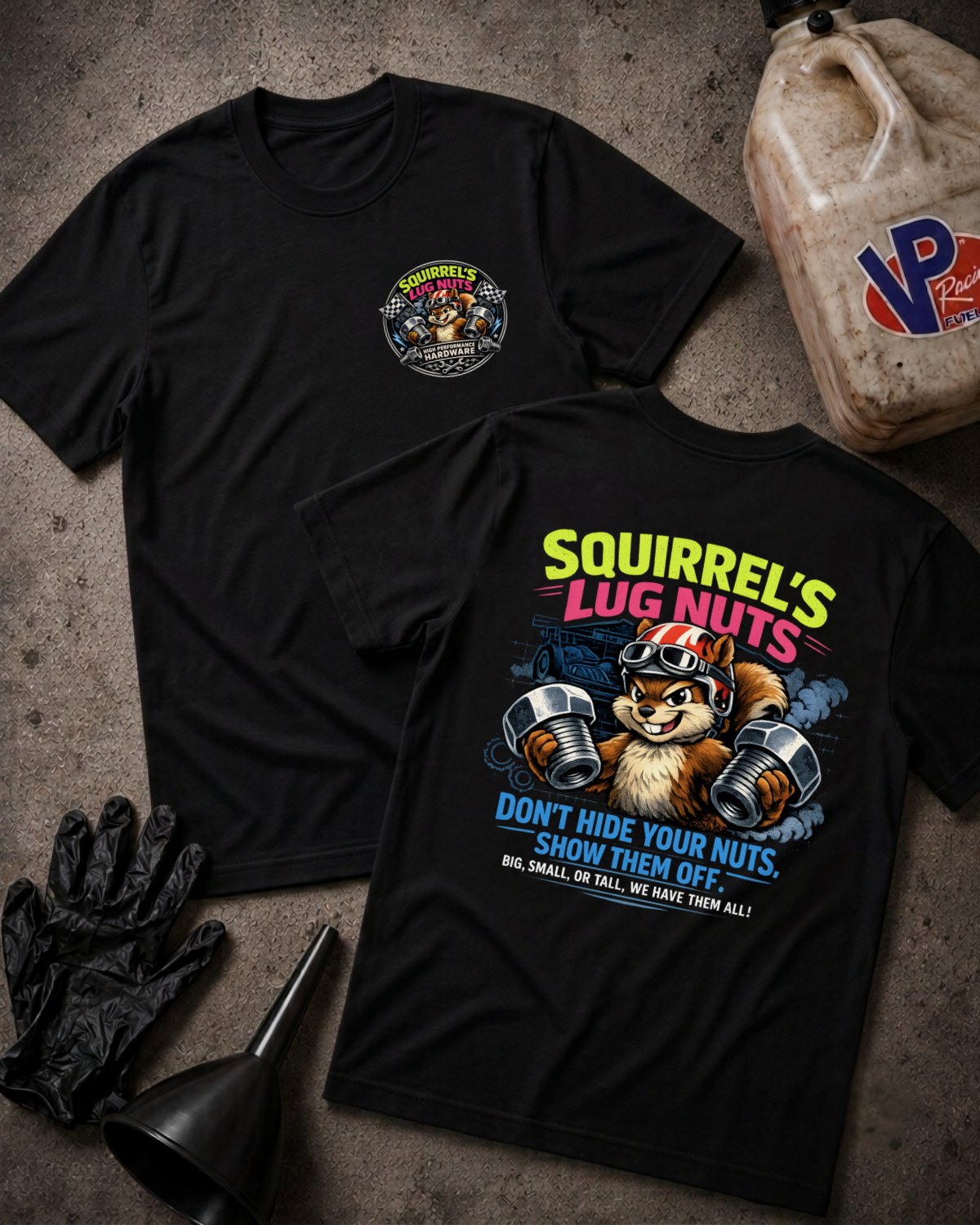 Two black graphic t-shirts laid flat on a textured gray surface, surrounded by black gloves, a funnel, and a plastic jug. The front shirt shows a small circular chest graphic, and the back shirt features a large colorful graphic of a squirrel lifting lug nuts with the text 'Squirrel's Lug Nuts'.