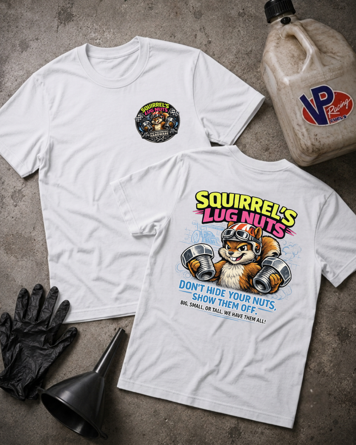 Two white graphic T-shirts laid flat on a gray concrete surface, with a black funnel, black gloves, and a plastic jug nearby. The front shirt has a small circular chest graphic, and the back shirt has a large colorful graphic reading 'Squirrel's Lug Nuts' with an illustrated squirrel holding lug nuts and slogan text below.