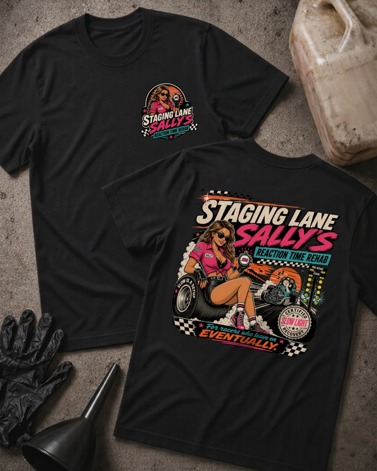 Front and back of Staging Lane Sally’s black T-shirt with chest logo, woman holding a stopwatch seated on a racing tire, and “For racers who leave on eventually” slogan.