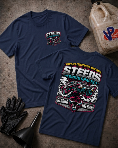 Two navy blue graphic T-shirts laid flat on a textured concrete-like surface, with automotive-themed printed artwork and the word 'STEEDS' visible. One shirt shows the front with a small chest graphic, and the other shows the back with a large multicolor graphic.