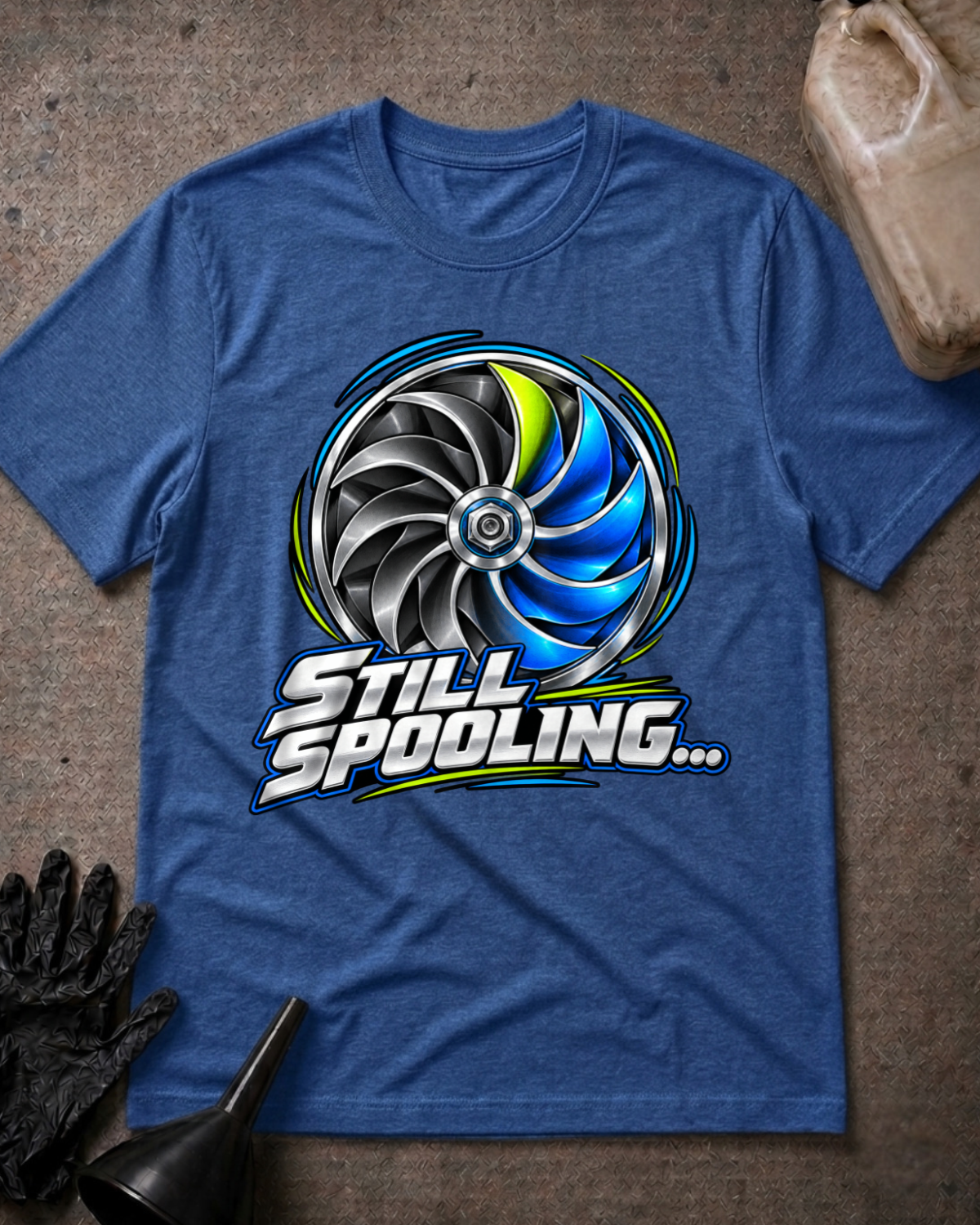 Heather true royal blue T-shirt laid flat with a silver, black and blue turbo wheel graphic, lime accents and bold silver “Still Spooling…” lettering.