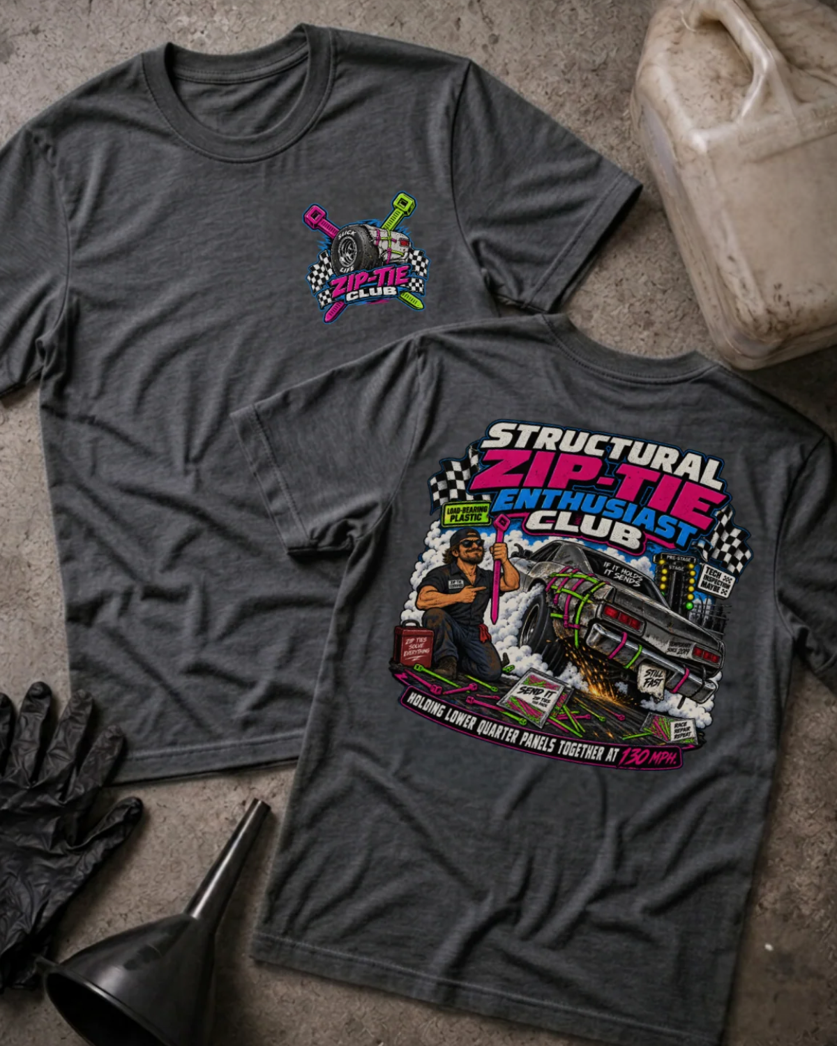 Front and back of Structural Zip-Tie Enthusiast Club dark grey heather T-shirt with chest logo, mechanic holding a pink zip tie, and drag car secured with colorful zip ties.