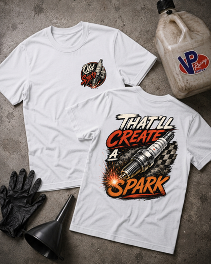 Two white graphic T-shirts laid flat on a gray concrete-style surface, with a black funnel, black gloves, and a VP Racing jug nearby. The front shirt has a small circular chest graphic reading Old Sparky, and the back shirt has a large spark plug graphic with the text 'THAT'LL CREATE A SPARK.