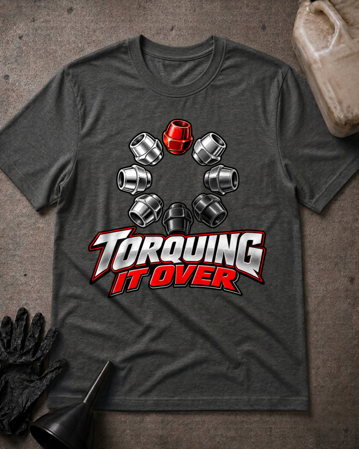 Dark grey heather T-shirt laid flat with a ring of silver and black lug nuts, one red lug nut at the top, and bold silver and red “Torquing It Over” lettering.