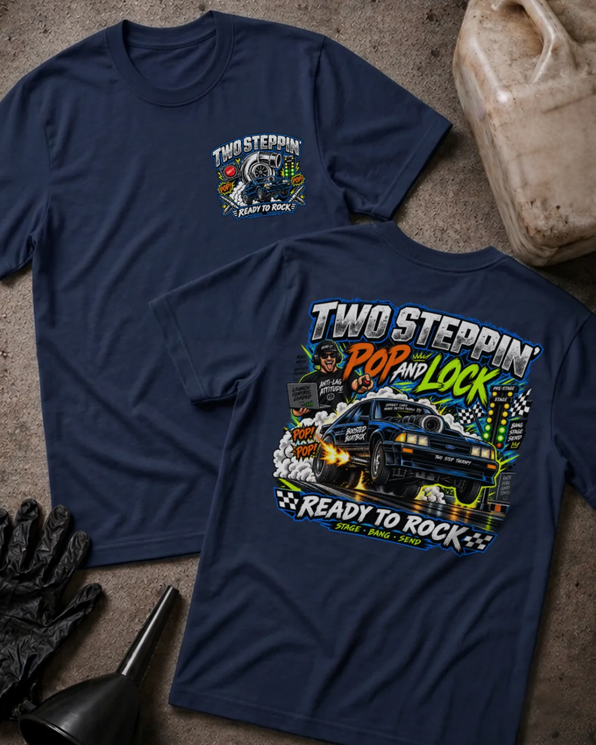 Front and back of Two-Step Pop and Lock navy T-shirt with chest logo, blue drag car launching amid smoke and flames, and “Two Steppin’ Pop and Lock, Ready to Rock” text.