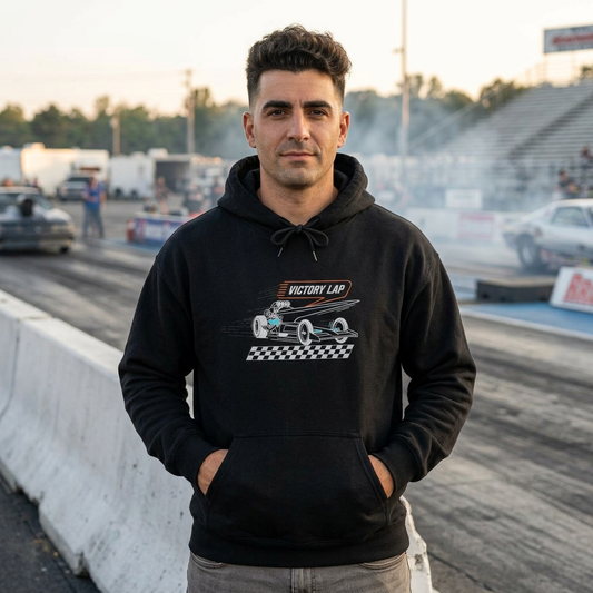 Man wearing a black hoodie with VICTORY LAP grapic, standing on a dragstrip