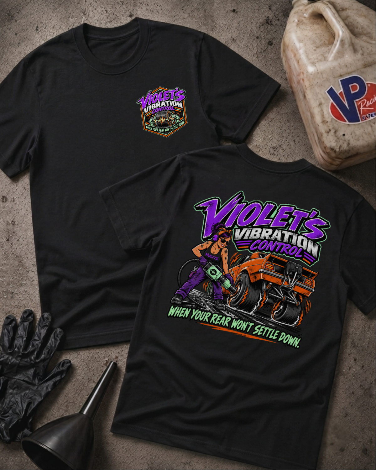 Two black graphic t-shirts showing a 'VIOLET'S VIBRATION CONTROL' logo on the front and a colorful graphic of a woman and a racecar with 'VIOLET'S VIBRATION CONTROL WHEN YOUR REAR WON'T SETTLE DOWN' text on the back