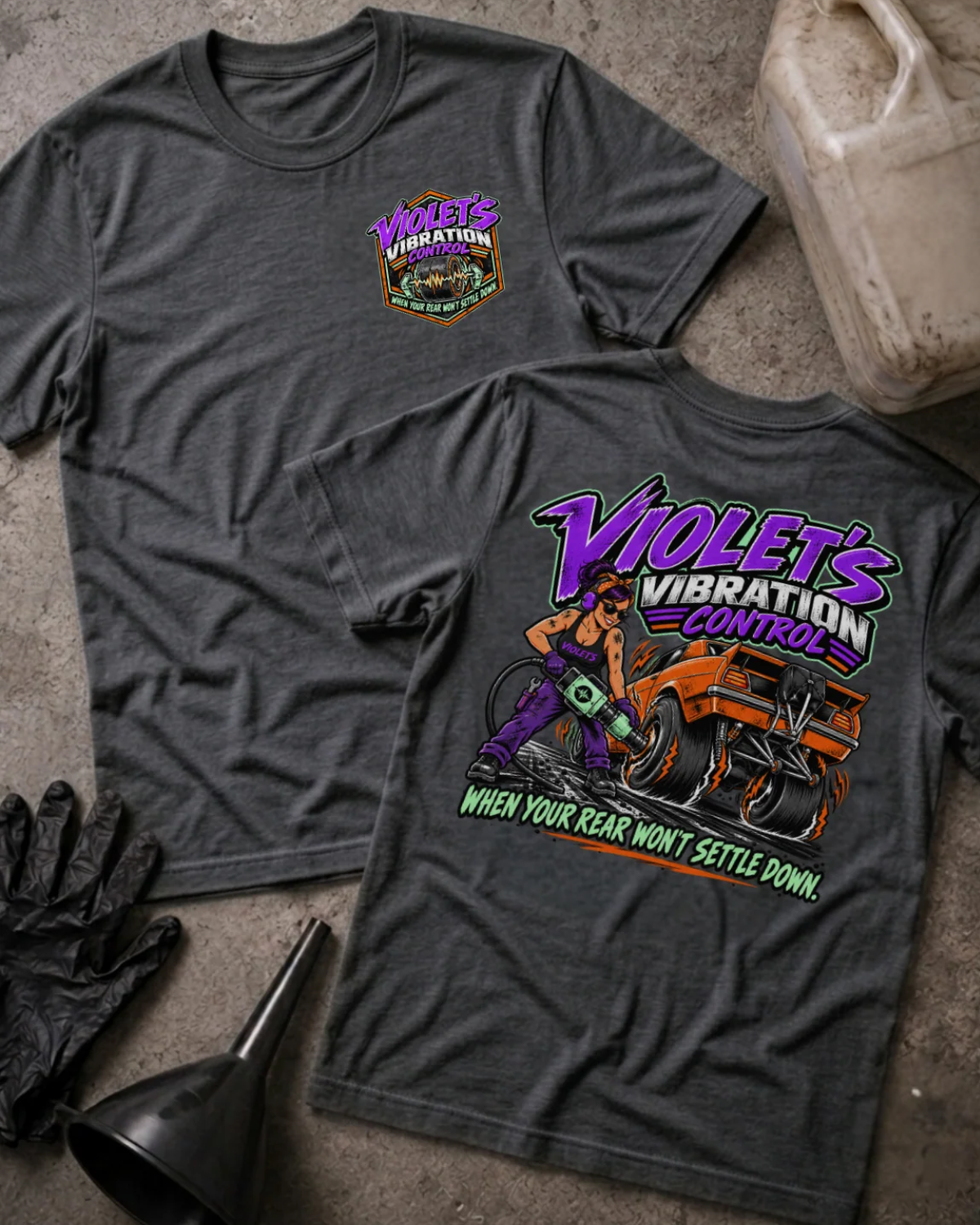 Front and back of Violet’s Vibration Control dark grey heather T-shirt with chest logo, woman holding a power tool beside an orange drag car, and “When your rear won’t settle down” slogan.