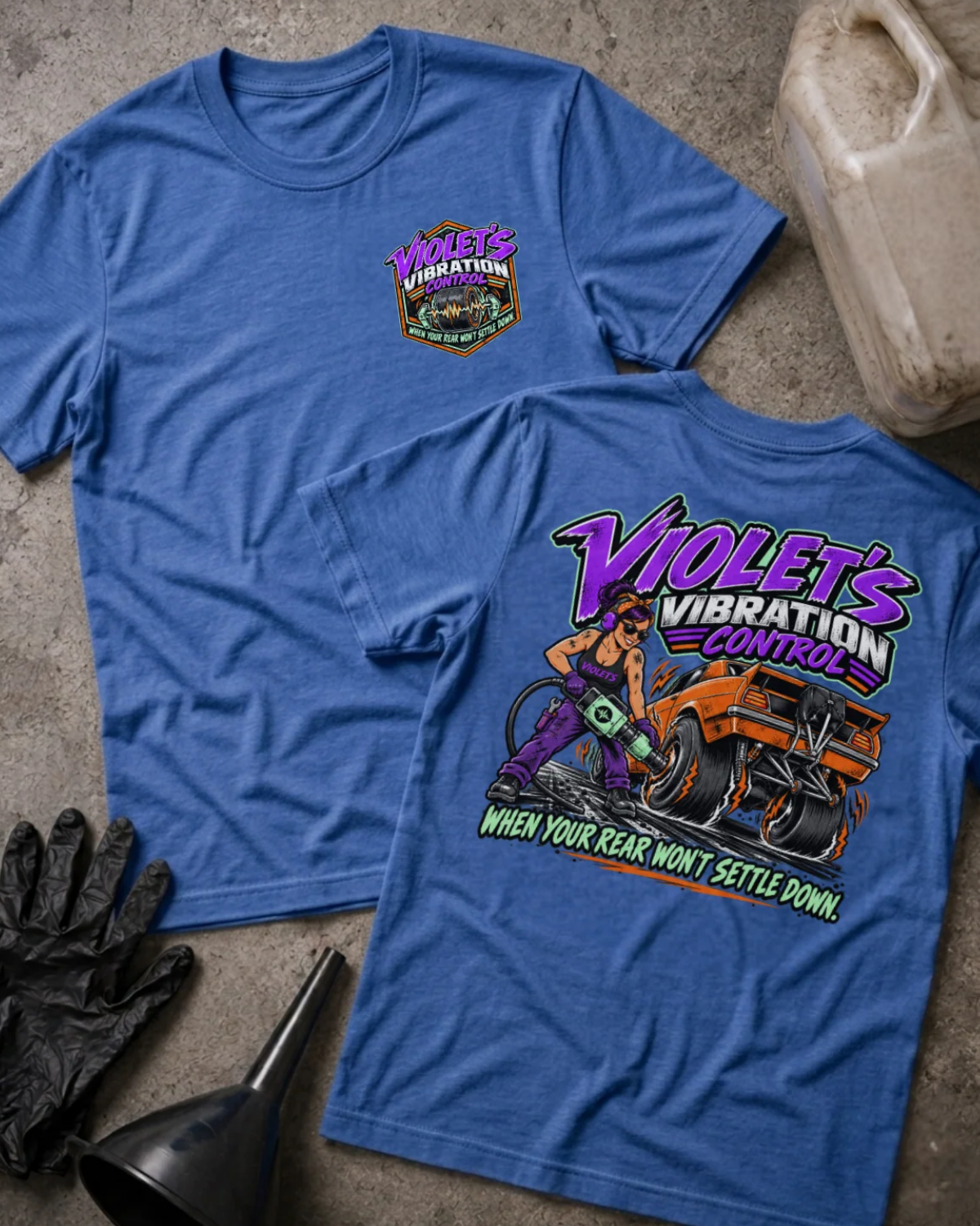 Front and back of Violet’s Vibration Control heather true royal T-shirt with chest logo, woman holding a power tool beside an orange drag car, and “When your rear won’t settle down” slogan.