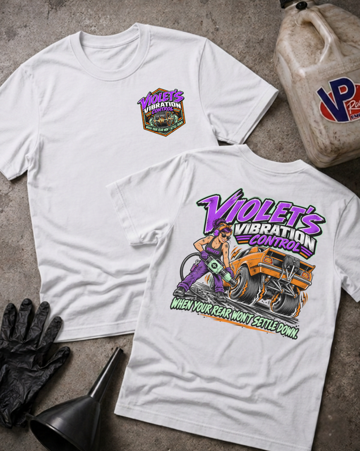 Two white graphic t-shirts showing a 'VIOLET'S VIBRATION CONTROL' logo on the front and a colorful graphic of a woman and a racecar with 'VIOLET'S VIBRATION CONTROL WHEN YOUR REAR WON'T SETTLE DOWN' text on the back