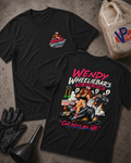 Two black graphic T-shirts laid flat on a textured gray surface, with racing-themed artwork and text. One shirt shows a small chest graphic, and the other shows a large back graphic with the words 'WENDY WHEELIEBAR'S BAD ADVICE HOTLINE' and 'Call before you lift'