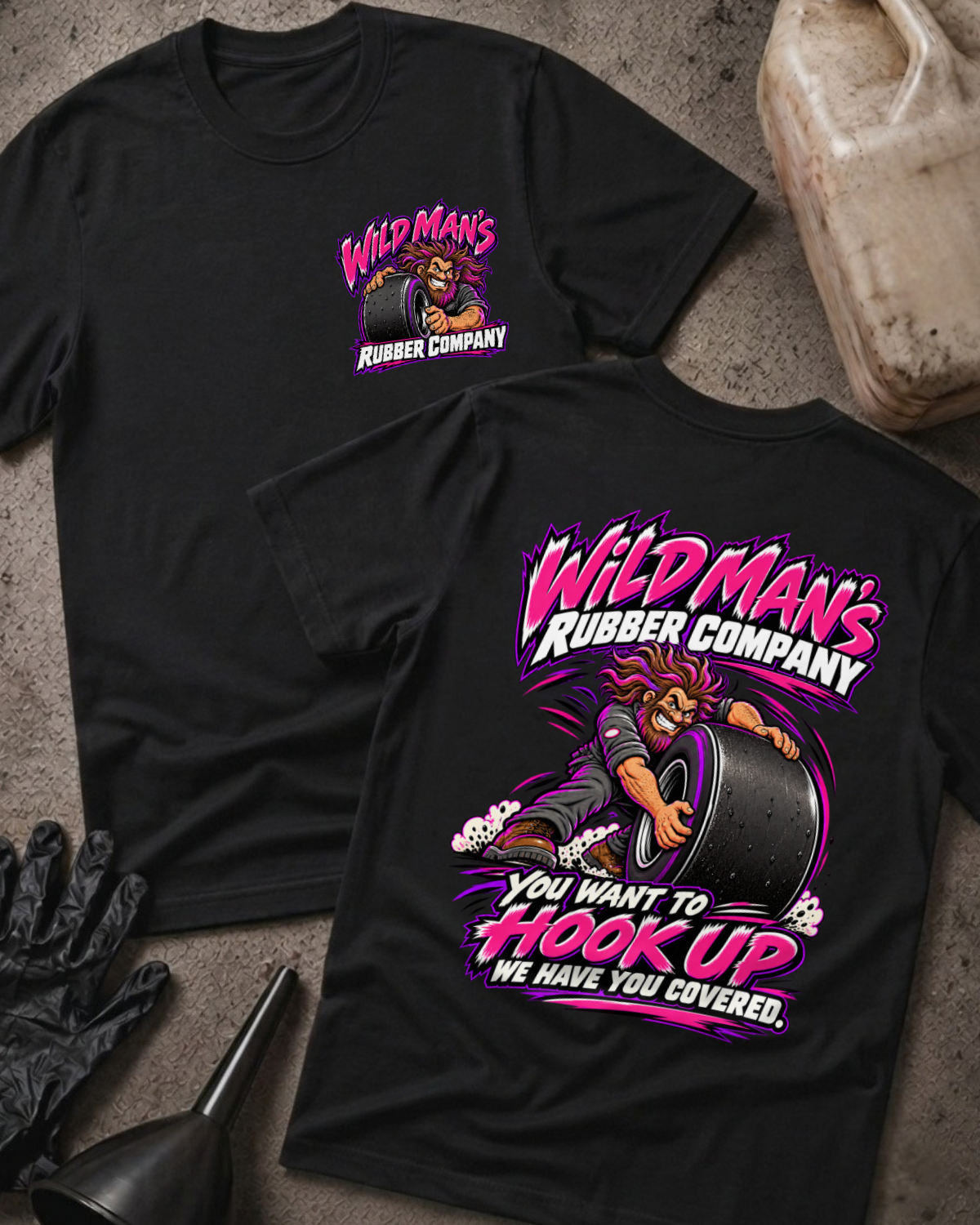 Black Wild Man's Rubber Company T-shirt, front and back views with pink-and-white graphics of a wild-haired man gripping a racing slick and “You want to hook up” slogan.