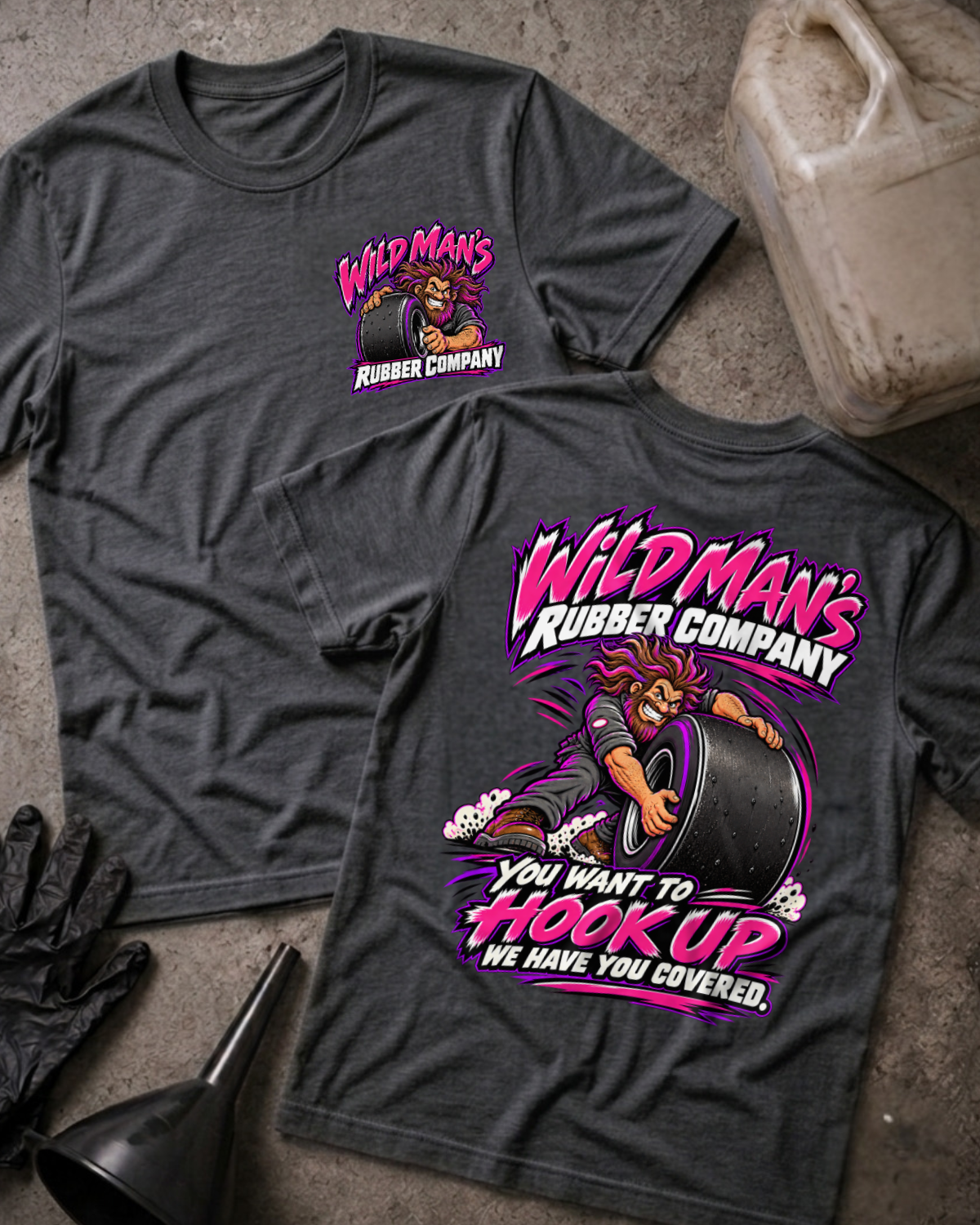 Dark Grey Heather Wild Man's Rubber Company T-shirt, front and back views showing a wild-haired man gripping a racing slick, pink lettering and “We have you covered” slogan.