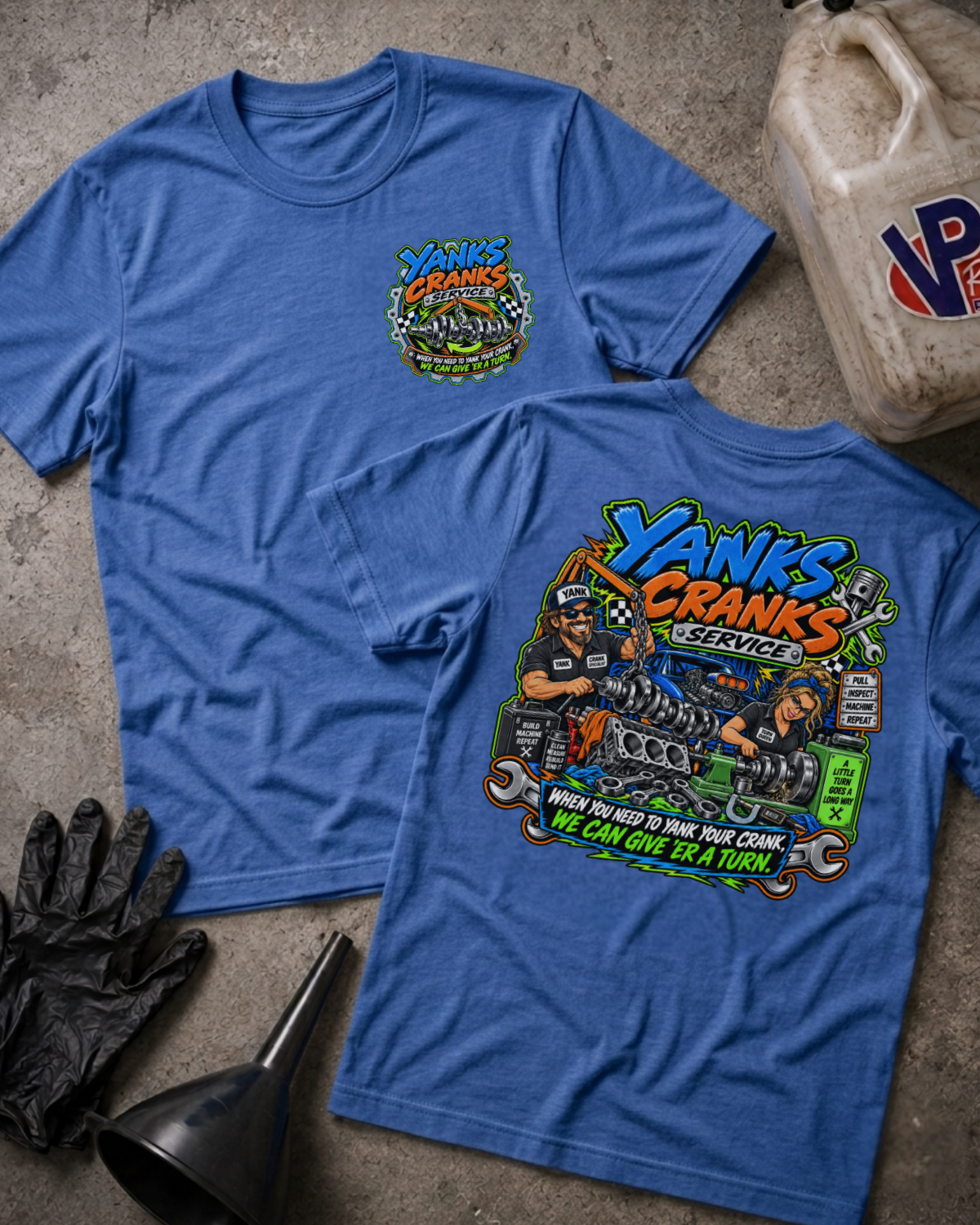 Two blue graphic T-shirts laid flat on a concrete surface, showing the front and back designs for 'Yanks Crank Service'. The shirts are styled with black gloves, a funnel, and a dirty fuel can.